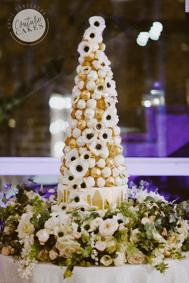 Croquembouche with serves 200 profiteroles £445, plus cake serves 75 portions £195, optional gold leaf £50 gold. Flowers provided by brides florist.